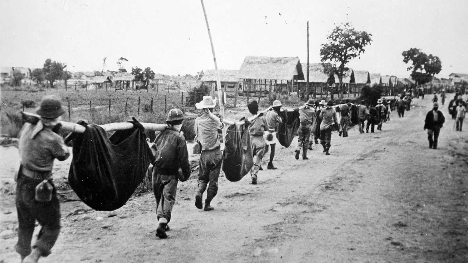 U.S. service members march toward a prisoner-of-war camp near Manila, Philippines.