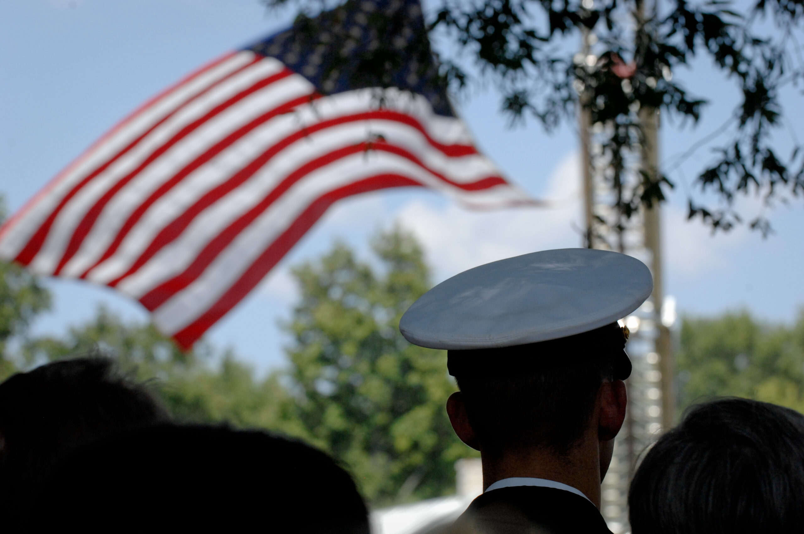 Individual in military uniform looking at the American Flag